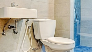 Une salle de bain équipée de toilettes, d’un lavabo et d’une douche.