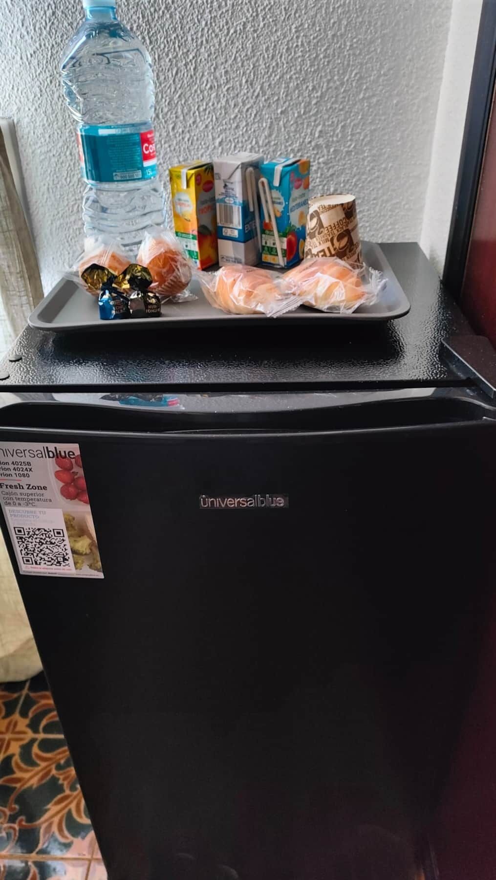 Un refrigerador con exterior negro y un adhesivo en la puerta.