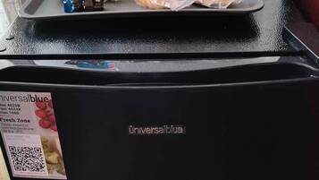 Un refrigerador con exterior negro y un adhesivo en la puerta.