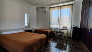 A hotel room with two single beds, a small table with a chair, a desk, and a wardrobe. - Pensión Benavente. 5 - (Playa 1,5km / AP7-3min) (Moncofa)