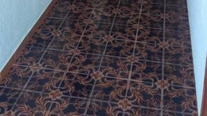 A hallway with patterned floor tiles, light green walls, and wooden doors. - Pensión Benavente. 5 - (Playa 1,5km / AP7-3min) (Moncofa)
