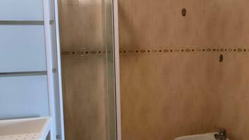 Ein Badezimmer mit Duschkabine, Toilette und Bidet.