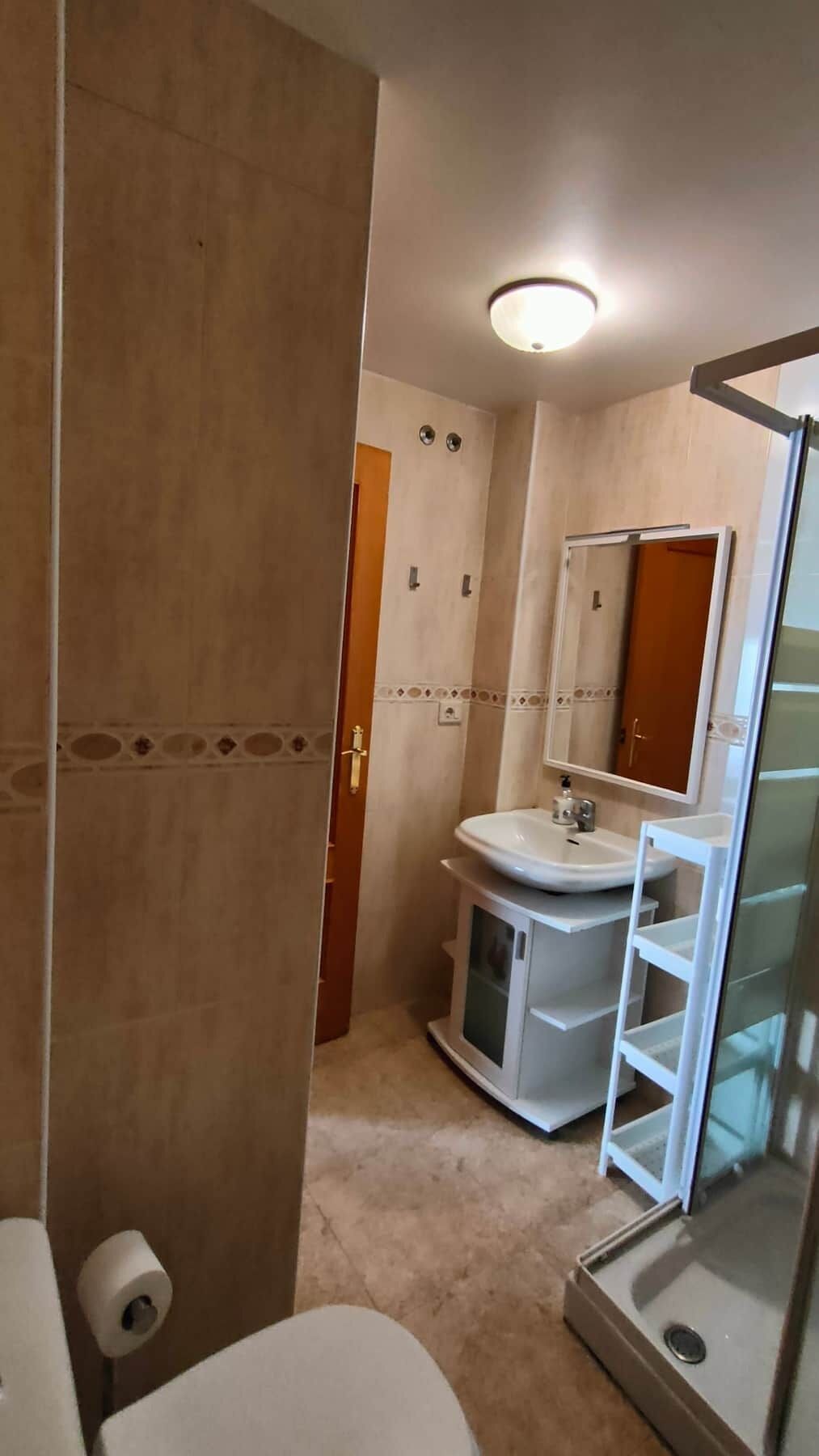Une salle de bain comprenant des toilettes, un lavabo et un espace douche.