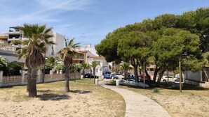 A coastal walkway with palm trees, a wooden boardwalk, and parked cars. - Paradis II (Seaviews) (El Grau de Moncofa)