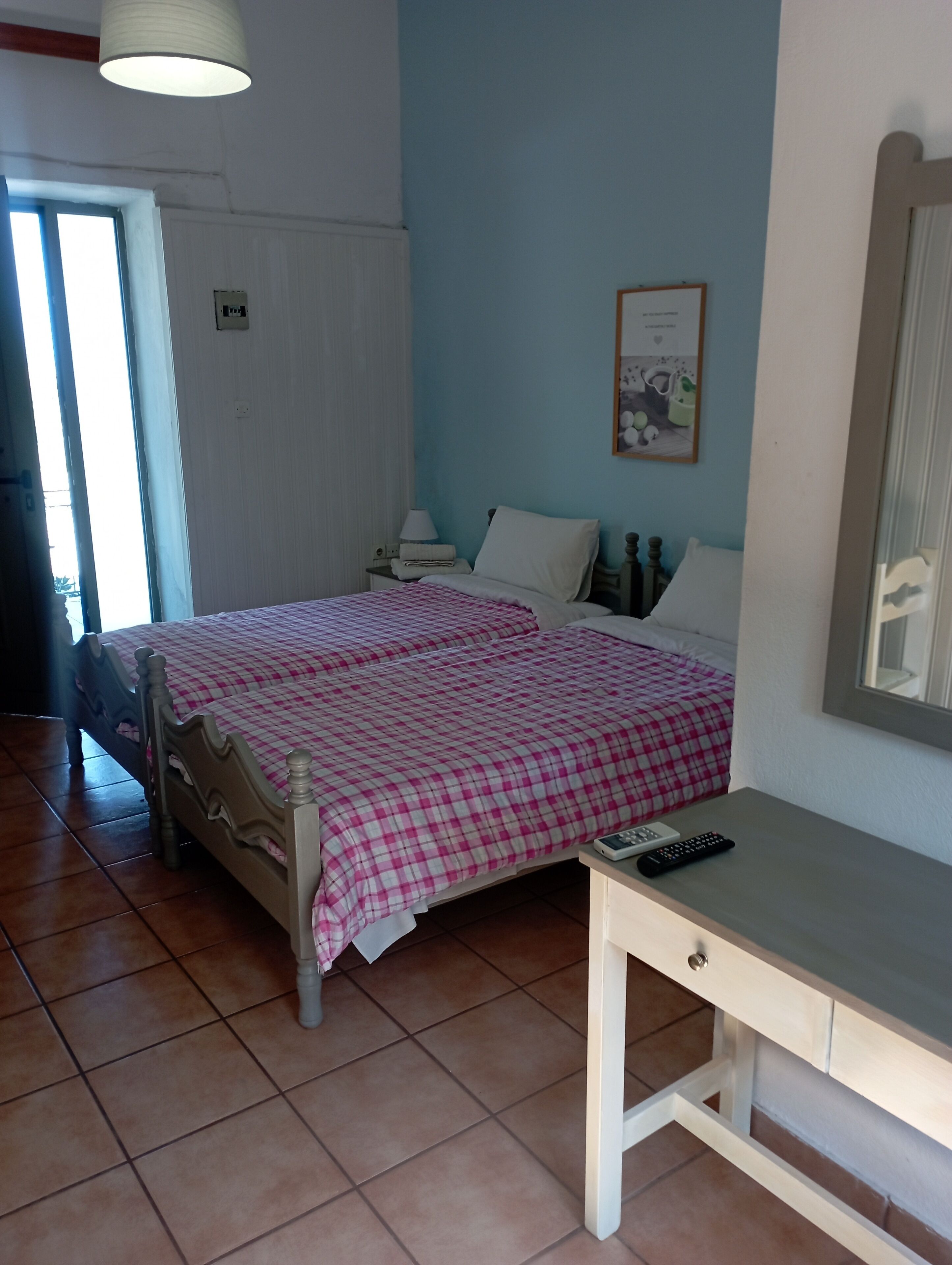 Un dormitorio con cama, mesita de noche y espejo.