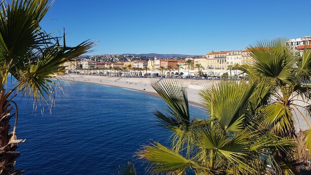 A coastal town with a beach, buildings, and palm trees. - Chic & Spacious Getaway in Nice - 10 min to Beach (Nice)