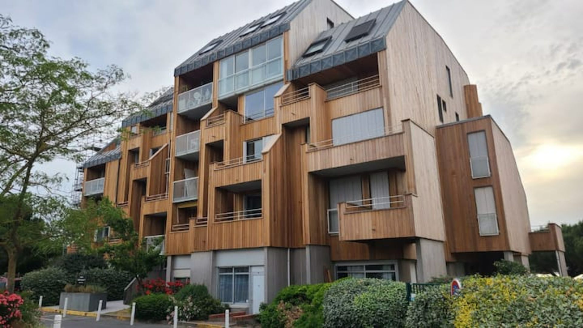 A multi-story building with balconies, large windows, and a modern architectural style.