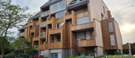 A multi-story building with balconies, large windows, and a modern architectural style.