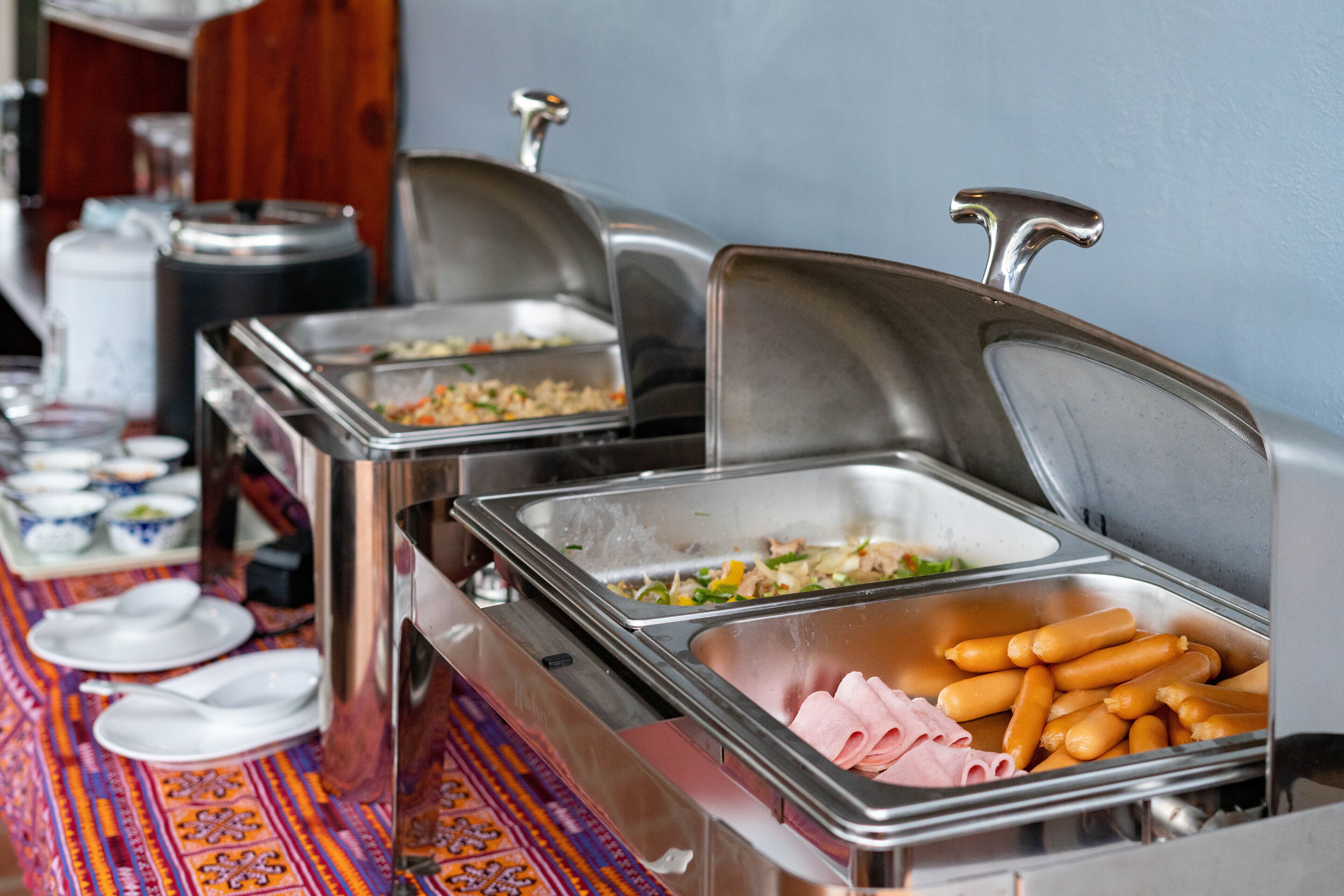 A buffet setup with various food items and dishes.