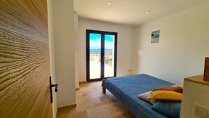 A bedroom with a bed, a door leading to a balcony, and a view of the outside. - Villa Indépendante - Piscine Privée - Clim - Vue Exceptionnelle (Orgnac l'Aven)