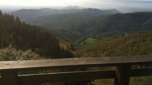 A wooden bench overlooking a valley with a distant mountain range. - Vacation Home Myrtle Bielmonte (piatto)