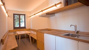 A compact kitchen with a wooden countertop, a sink, a window, and a bench. - Vacation Home Myrtle Bielmonte (piatto)
