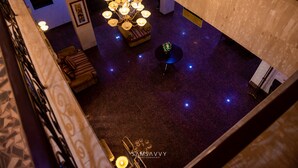 A spacious lobby with a high ceiling, a chandelier, and a seating area. - Dees Hotels (Lagos)