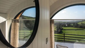 Una habitación con amplias ventanas en arco que dan a un paisaje verde.