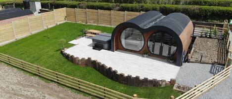 A modern outdoor kitchen area with a built-in grill, seating, and a view of the surrounding countryside.