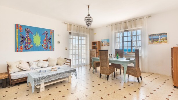 A spacious living room with a sofa, a dining table with chairs, a chandelier, and artwork on the walls. - 3315 Villetta Carmela by Barbarhouse (Alliste)