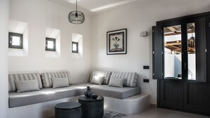 A modern living room with a sectional sofa, two round side tables, and a framed artwork on the wall.