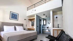 A bedroom with a bed, a desk, and a chair. There is a wardrobe and a mirror.