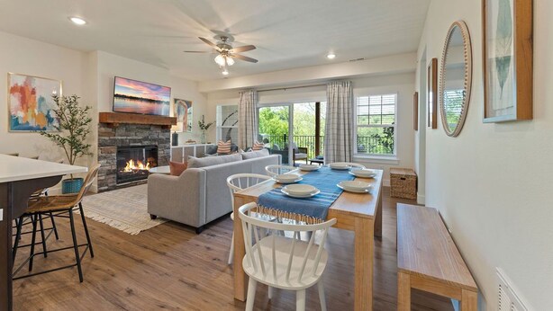 Amplia sala de estar con chimenea, una mesa de comedor lista para cuatro personas y un cómodo espacio para sentarse.