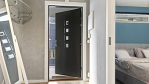 A room with a bed, a door, and a window. - Mitt hotell apartments (Moss)