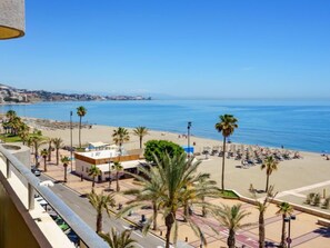 A beachfront hotel with a view of the sea, palm trees, and beach umbrellas. - Fuengirola Beach View by Interhome (Fuengirola)