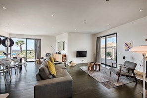 Relax in this stylish living room with a large sofa, coffee table, and flat-screen TV.