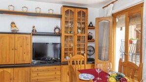 Ein Essbereich mit Holzsäcken, einem Fernseher und einer Obstschale auf dem Tisch.