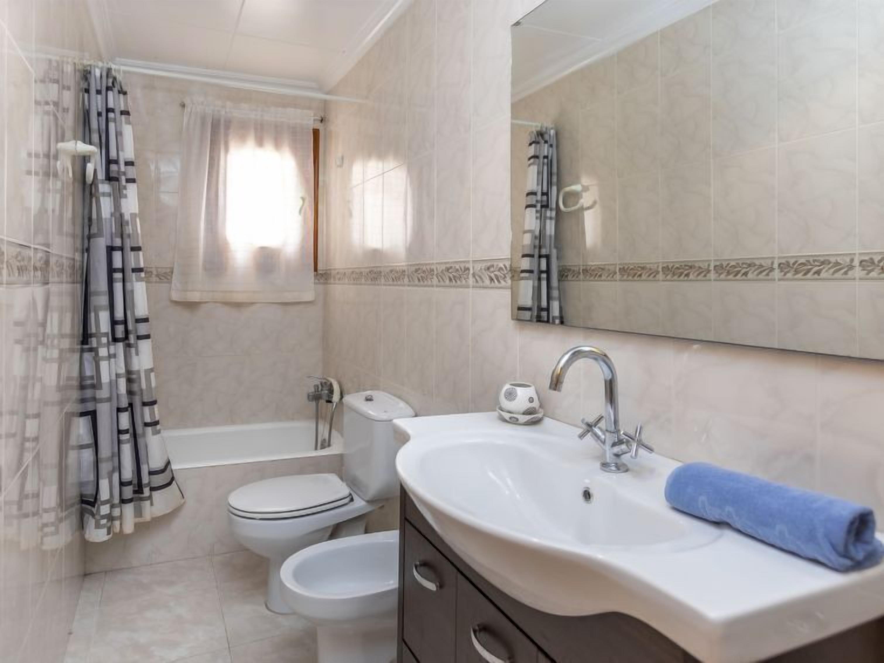 A bathroom with a bathtub, toilet, bidet, and sink.