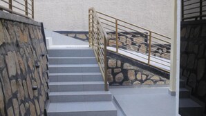Una escalera con paredes de piedra y barandilla de metal.