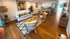 A modern living room with a sofa, chairs, and a dining area. - Condo on the beach (Collectivité de Saint-Martin)