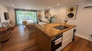 A modern kitchen with a wooden countertop, white cabinets, and a built-in oven. - Condo on the beach (Collectivité de Saint-Martin)