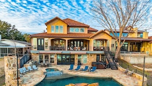 A two-story house with a swimming pool, stone steps, and outdoor seating. - Beachfront Villa | Concierge Services (Kingsland)