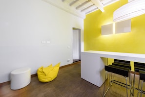 Relax in a stylish space with a comfortable bean bag chair and a convenient dining area.