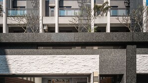 Een modern gebouw met een plat dak, grote ramen en een stenen gevel.