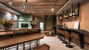 Een moderne keuken met een houten aanrecht, barkrukken en een televisie.
