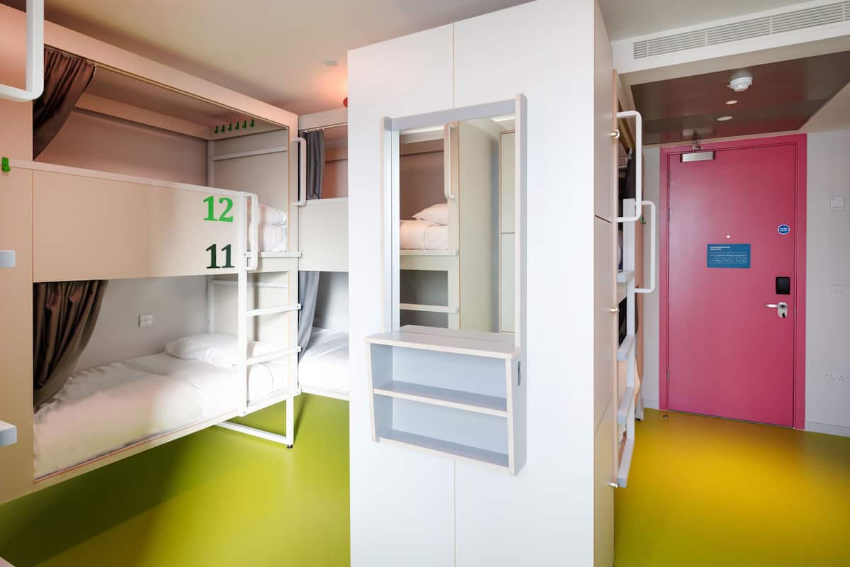 A room with bunk beds, a wardrobe, and a door with a security lock.