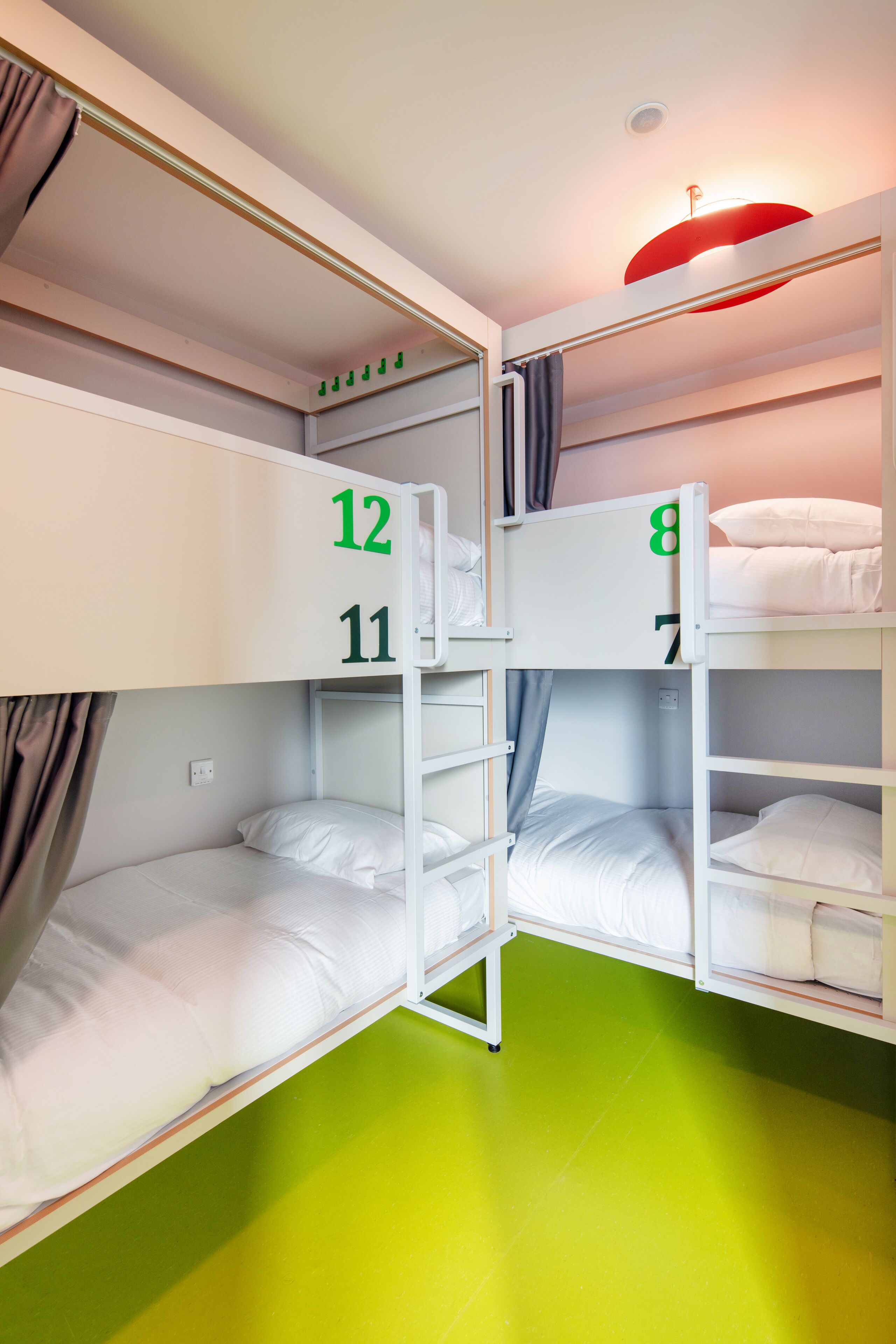 Een slaapkamer met stapelbedden, genummerd 8, 11 en 12.