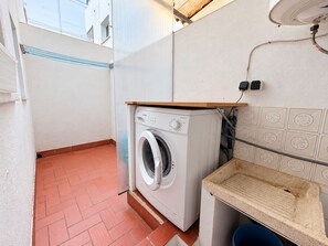 A compact laundry area with a washing machine, a small sink, and a tiled backsplash. - WIMPY esc.B 1º  Solo Familias! (Xeraco Playa)