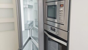 A modern kitchen with built-in appliances including a microwave, oven, and refrigerator.