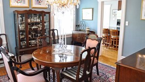 A dining room with a round table, chairs, a chandelier, and a china cabinet. - Comfortable Home 3 blocks from the beach at the Jersey Shore (Belmar, North end) (Belmar)