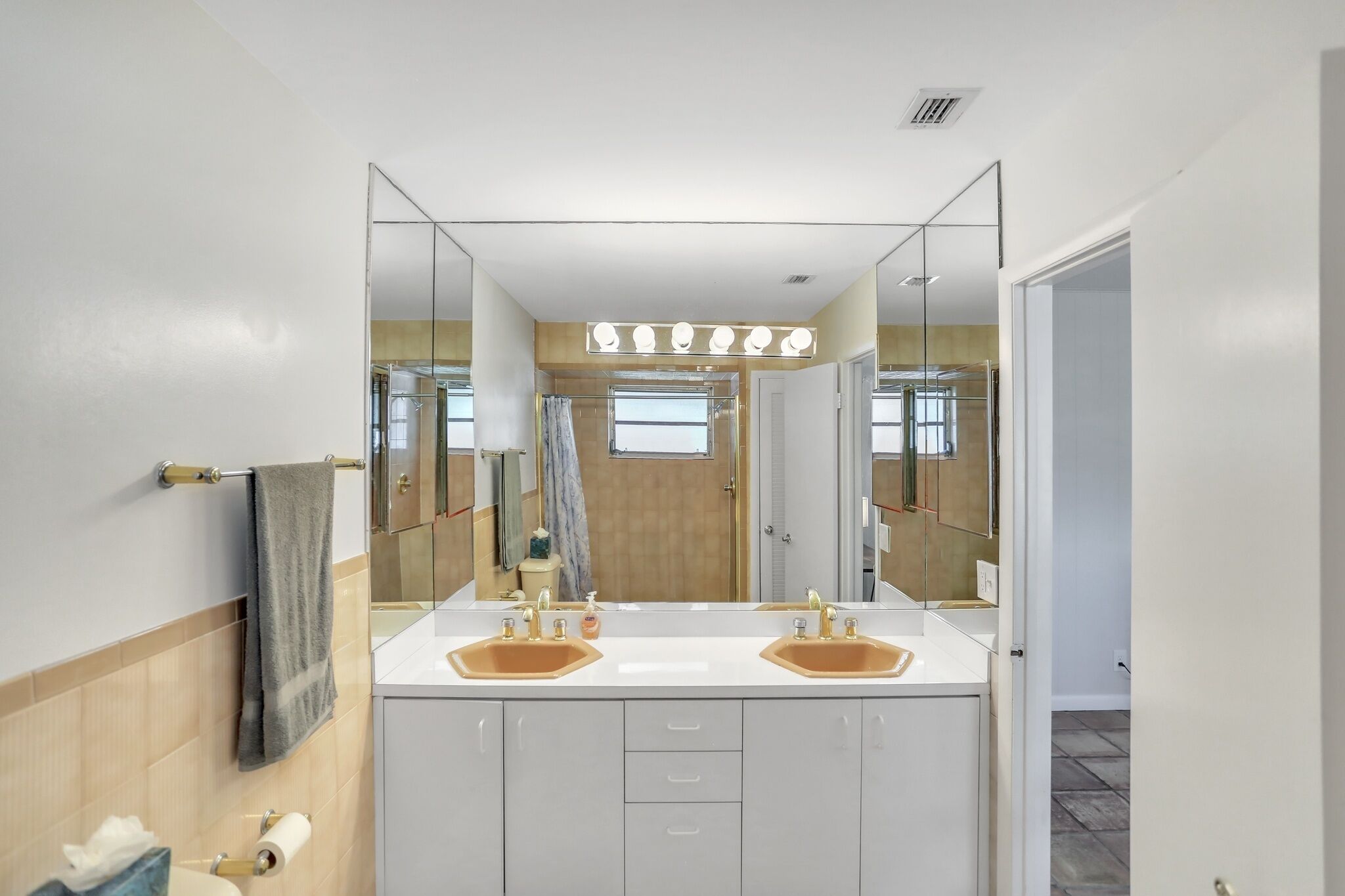 Een moderne badkamer met een grote spiegel, twee wasbakken en een douche.