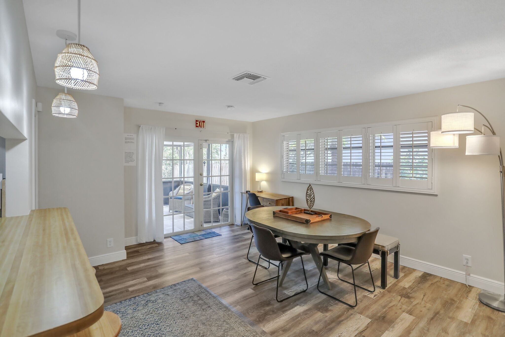 A dining area with a round table, chairs, and pendant lighting.