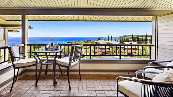 A balcony with a table and chairs, overlooking a scenic ocean view. - Kapalua Ridge Villa 1624 By Parrish Maui - New Listing & Value (Lahaina)