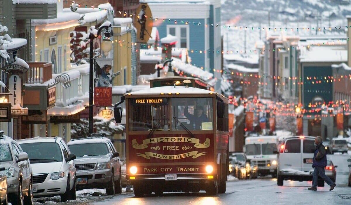 En historisk, gratis spårvagn på Main Street, med snö på marken och byggnader i bakgrunden.