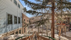 A staircase leading to a building with a metal railing and snow on the ground. - Modern 2BR Steps from Main St! (Park City)