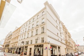 Un edificio de varios pisos con un estilo arquitectónico clásico, que cuenta con un escaparate en la planta baja con grandes ventanales y un letrero de “prohibido el acceso”.