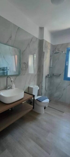 A modern bathroom with a marble sink, toilet, and shower. - Augustela Villa Seaview Vacation Villa (Kefalonia)