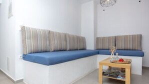 Una sala de estar moderna con un sofá modular, una mesita de madera y un aplique de pared.