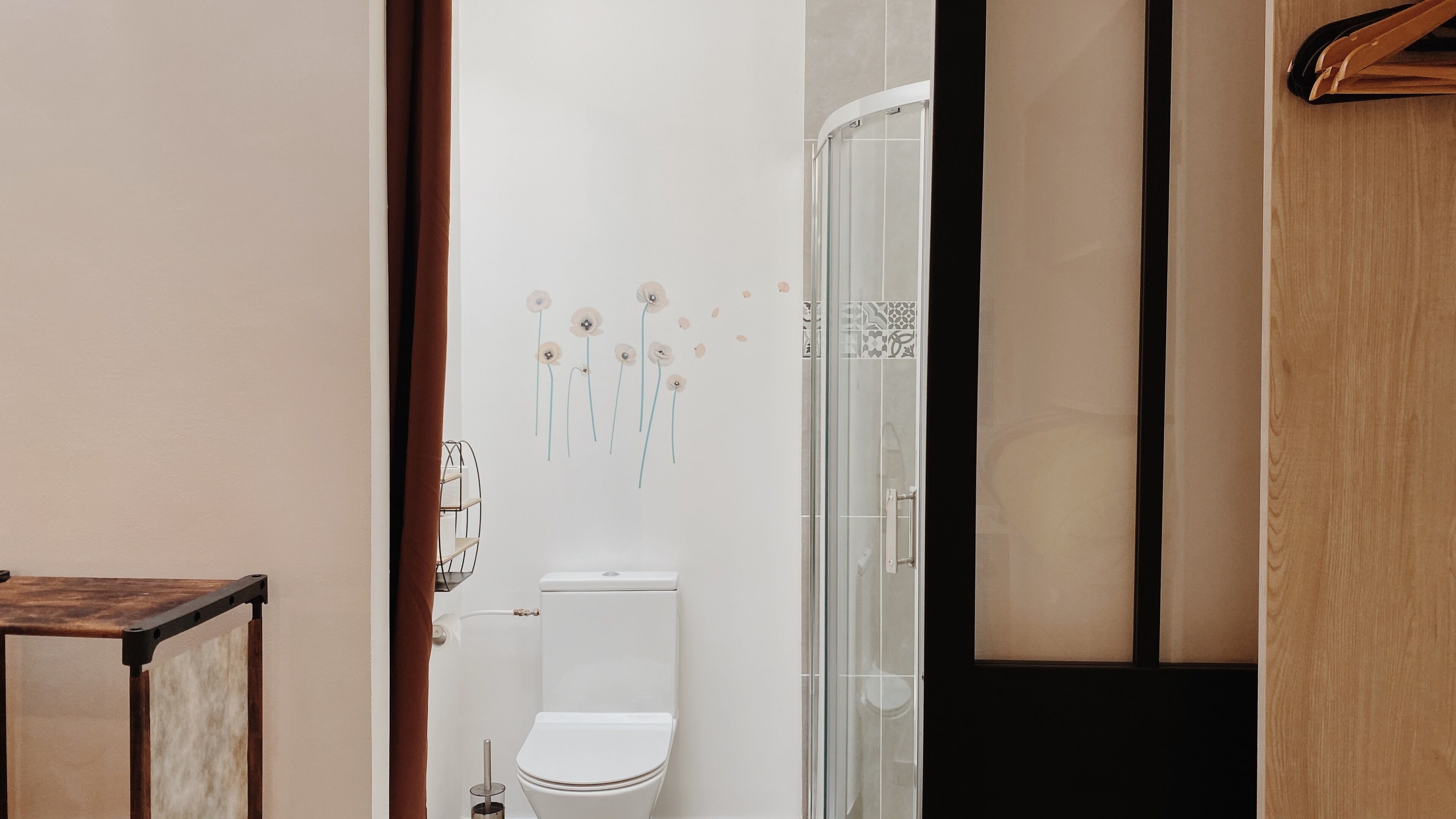 Une salle de bain équipée de toilettes, d’une douche et d’un porte-serviettes.