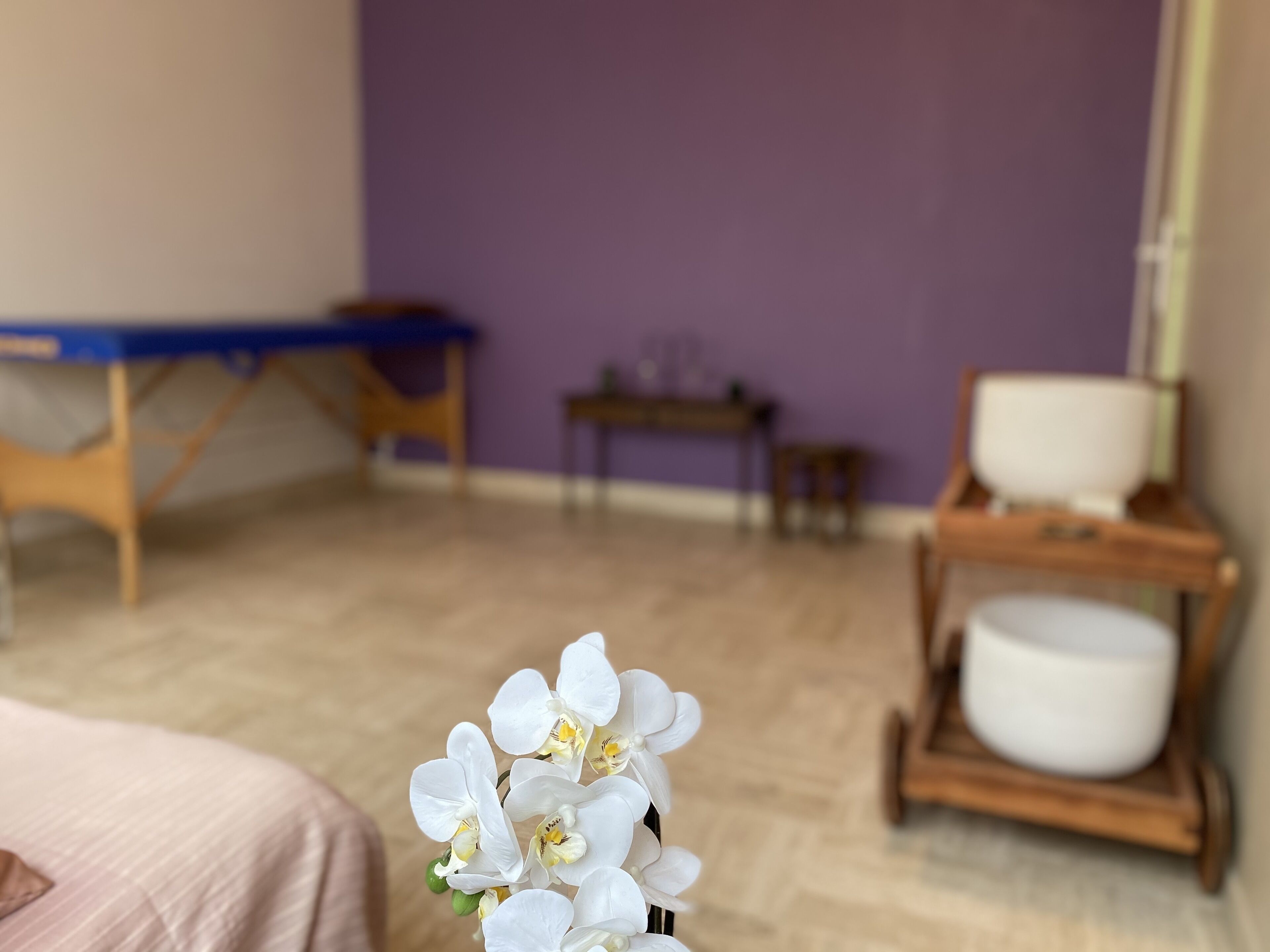 A room with a bed, a wooden table, a small table, and a chair.